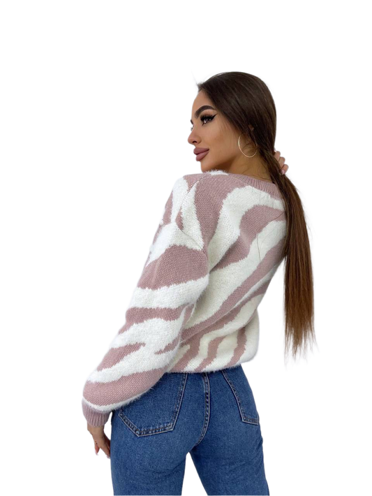 Woman wearing a patterned sweater and jeans on a white background