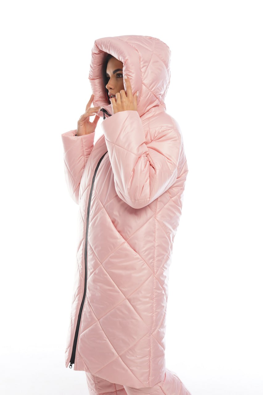 Person wearing a pink quilted jacket on a white background