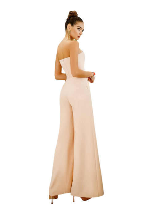 Woman wearing a strapless beige jumpsuit on a white background