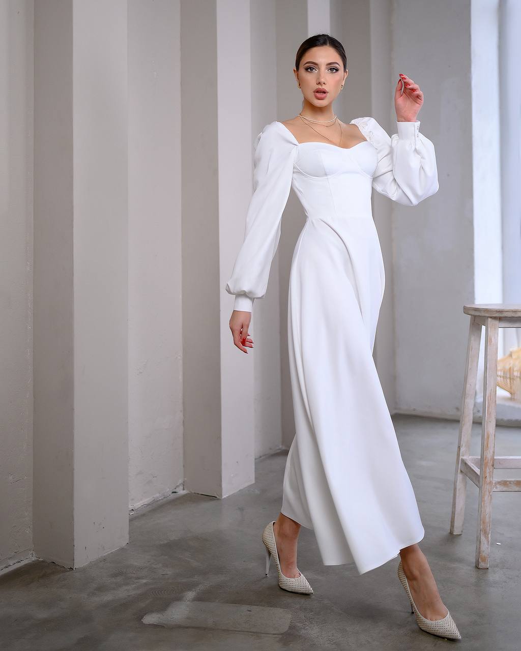 Woman wearing a white dress in a minimalistic room