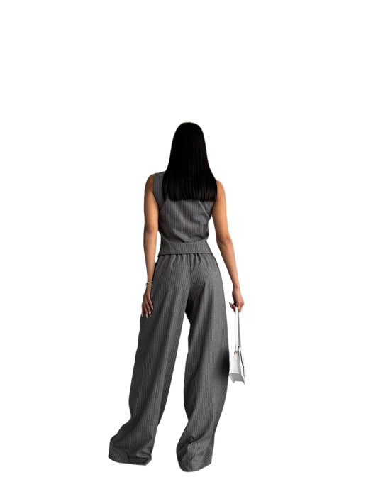 Woman wearing a gray sleeveless top and wide-leg pants on a white background