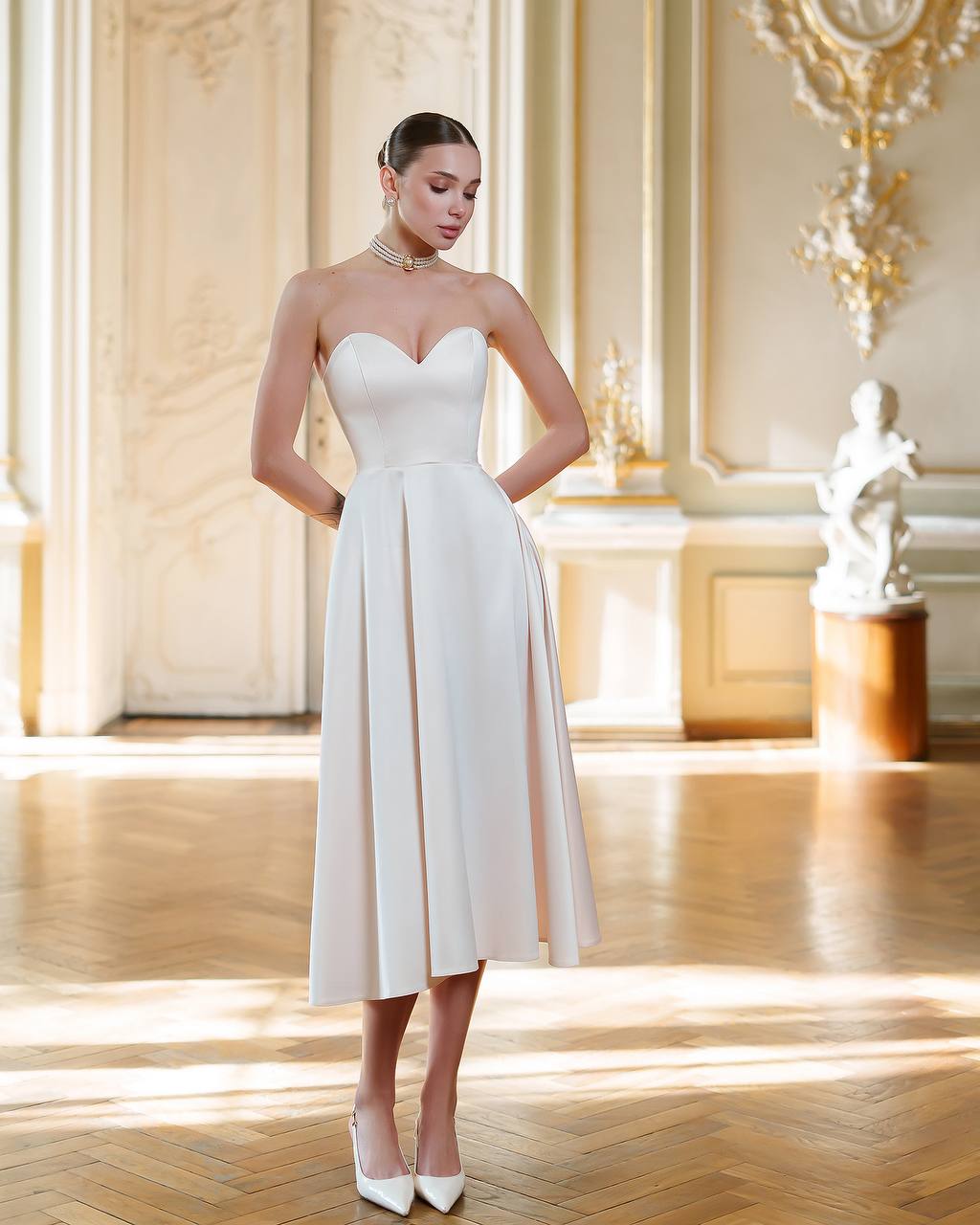 Woman wearing a white strapless dress in an elegant interior setting
