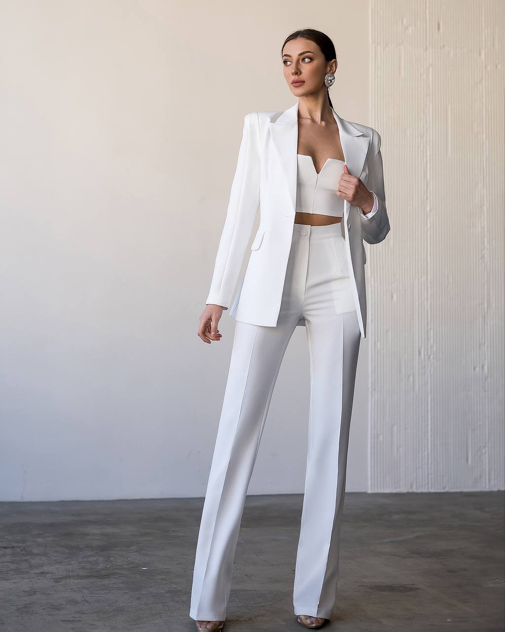 Woman wearing a white suit with a plain background