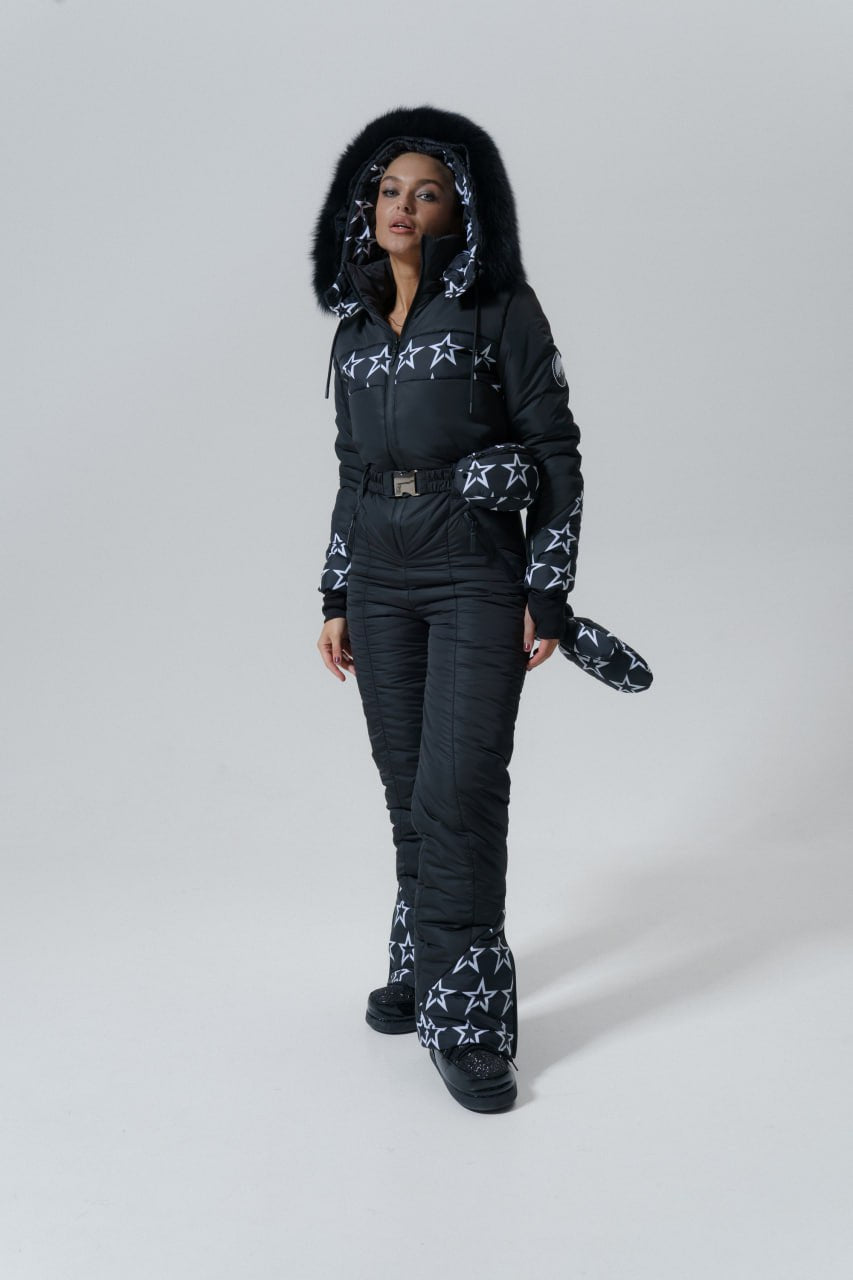 Person wearing a black snowsuit with white patterns on a gray background