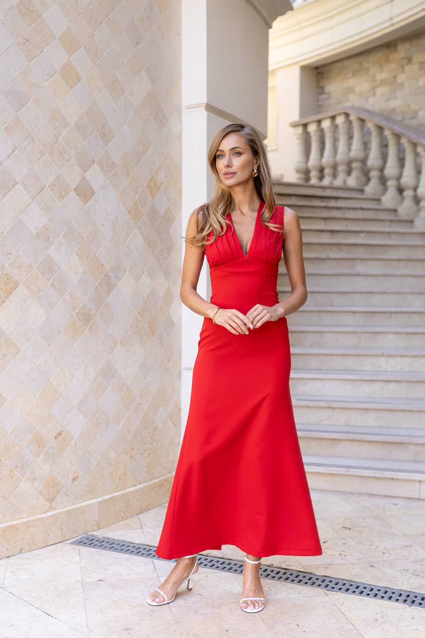 Woman in a red dress standing in an elegant interior setting