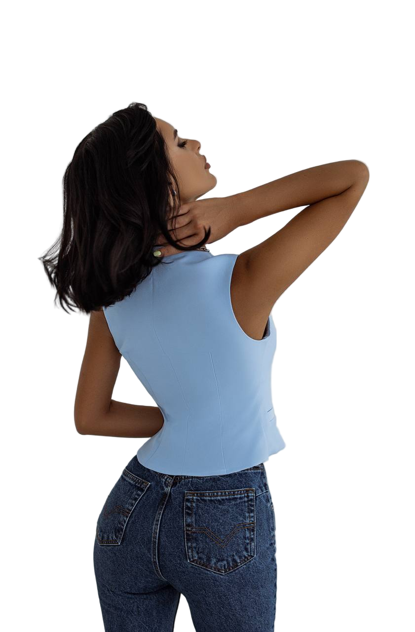 Woman wearing a light blue sleeveless top and dark blue jeans on a white background
