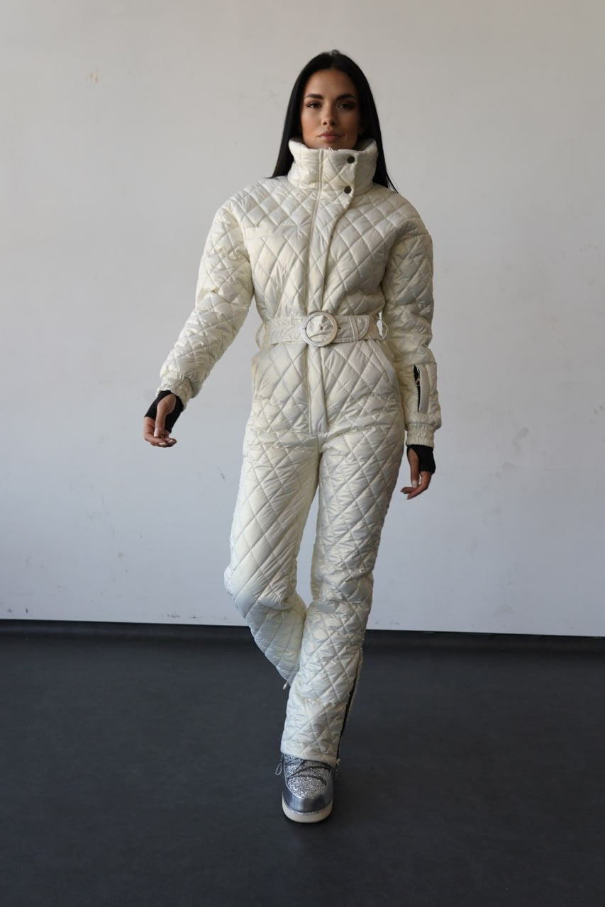 Person wearing a white quilted snowsuit against a plain background