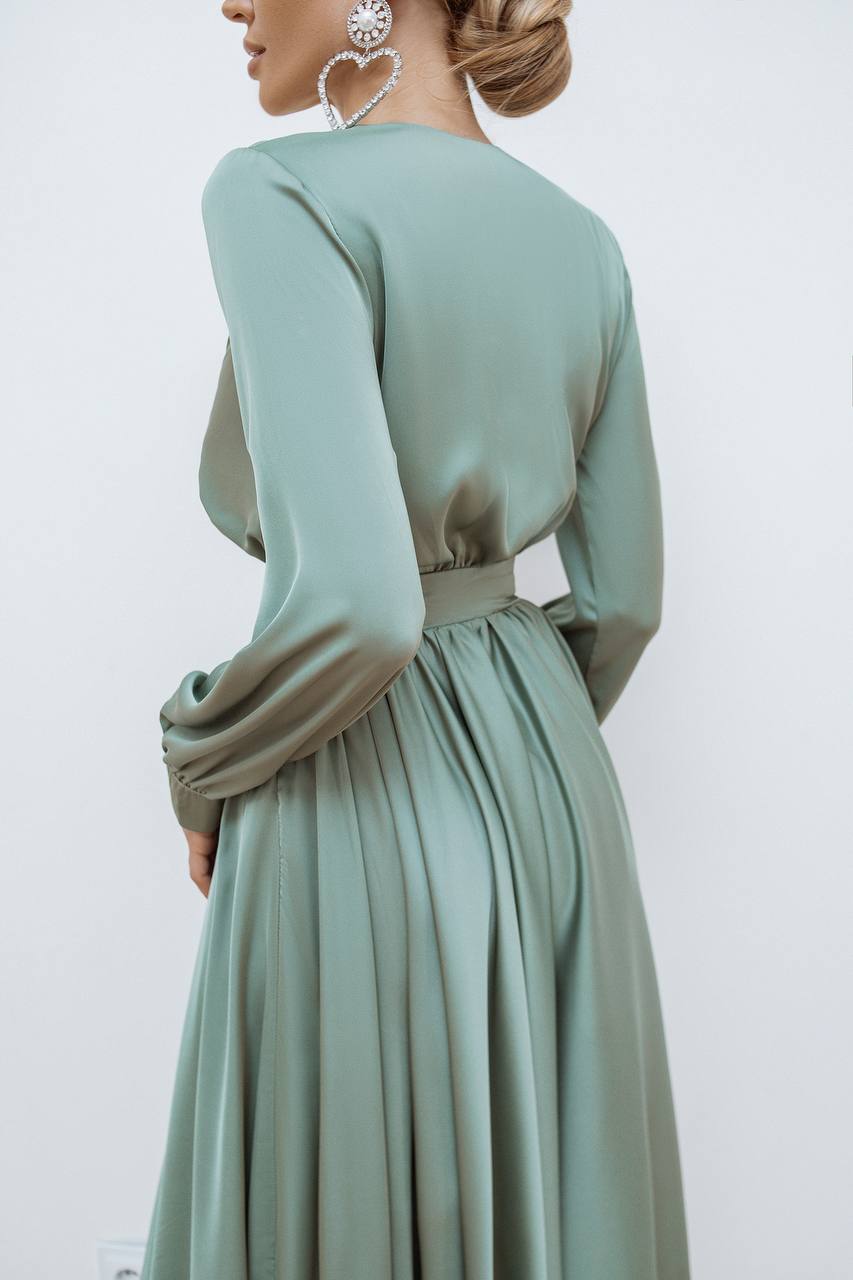 Mint green dress with long sleeves on a plain background