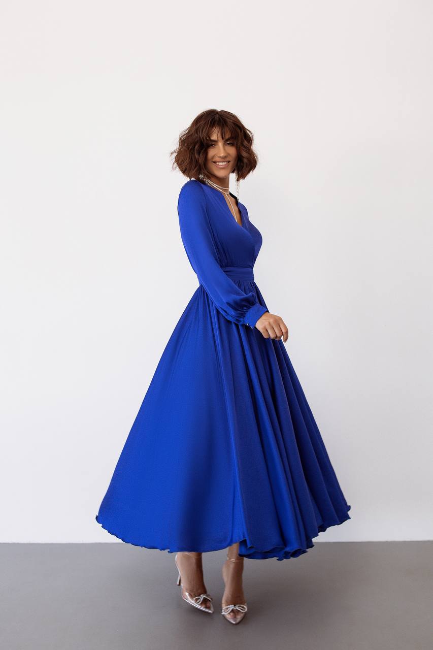 Woman wearing a blue dress against a white background