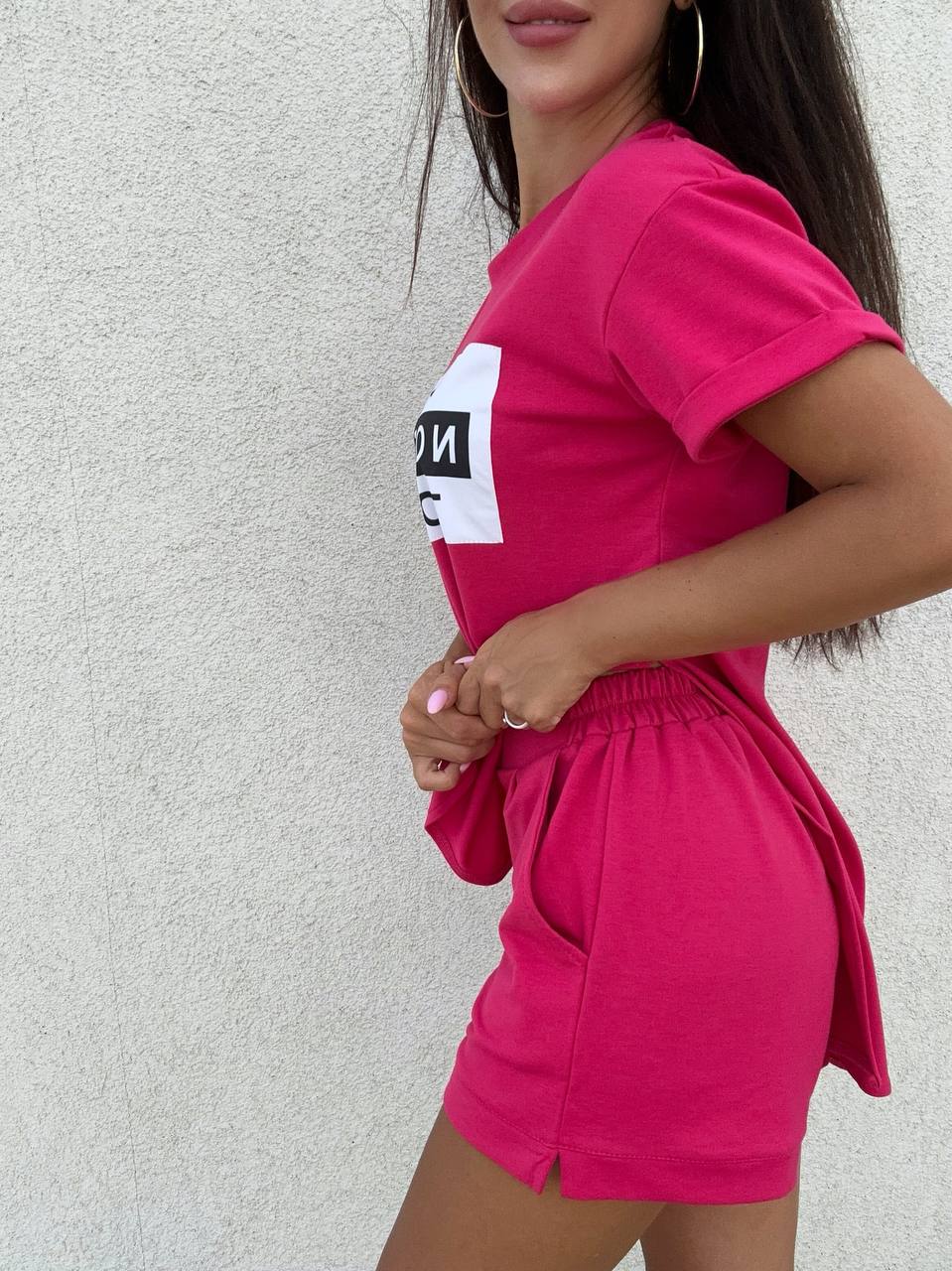 Woman wearing a bright pink outfit with a white background