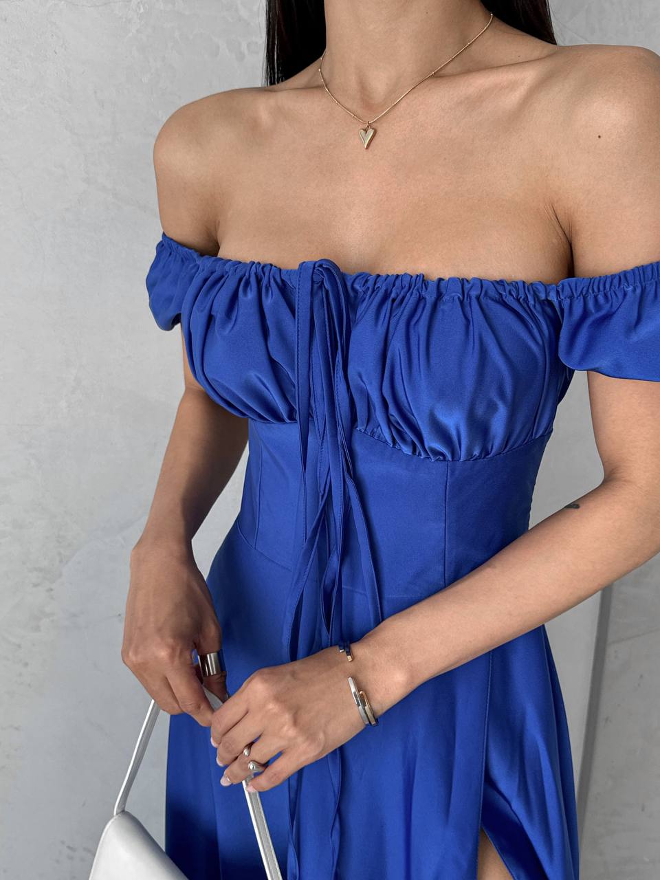 Blue off-shoulder dress worn by a person against a neutral background