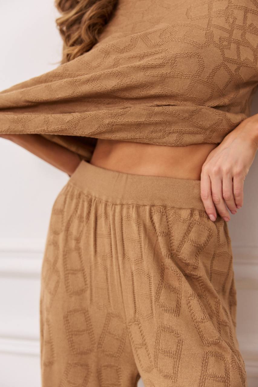 Person wearing a brown textured top and pants against a neutral background