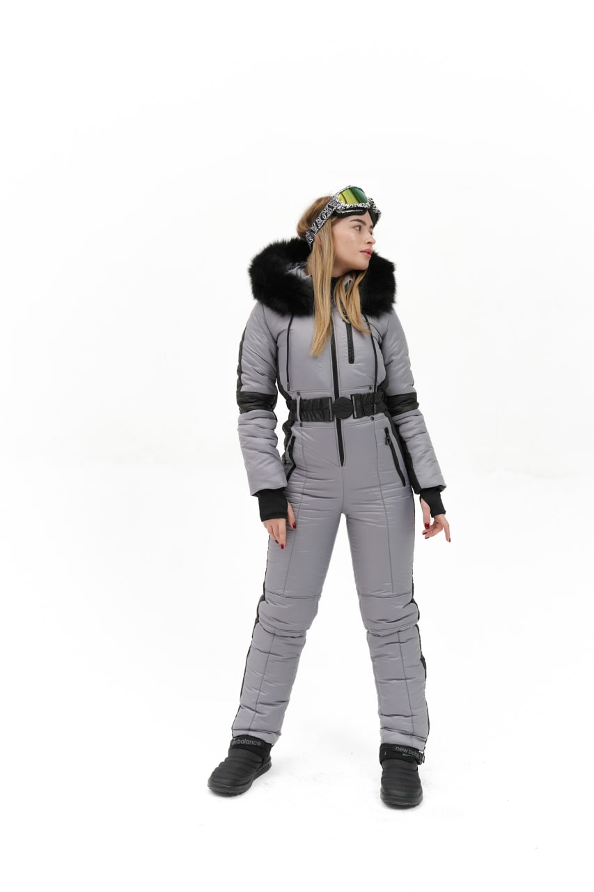 Person wearing a gray snowsuit with black accents on a white background