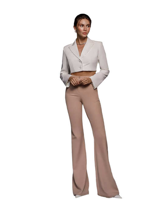 Woman wearing a white cropped blazer and beige flared pants on a white background
