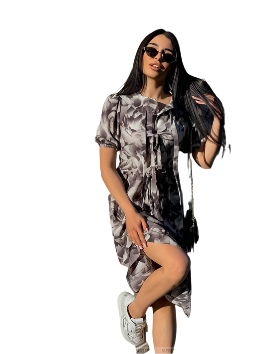 Woman wearing a patterned dress and sunglasses on a white background