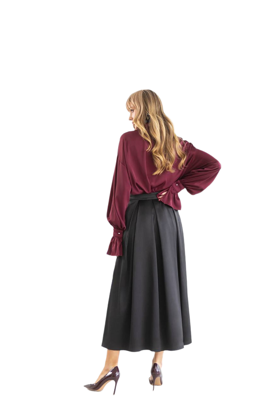 Woman wearing a burgundy blouse and black skirt on a white background