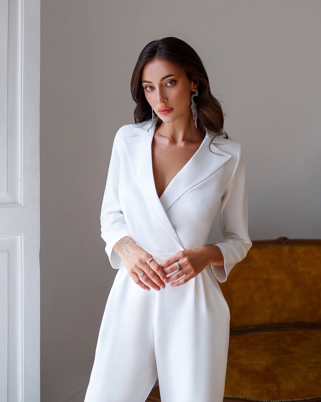 Woman wearing a white blazer dress against a neutral background