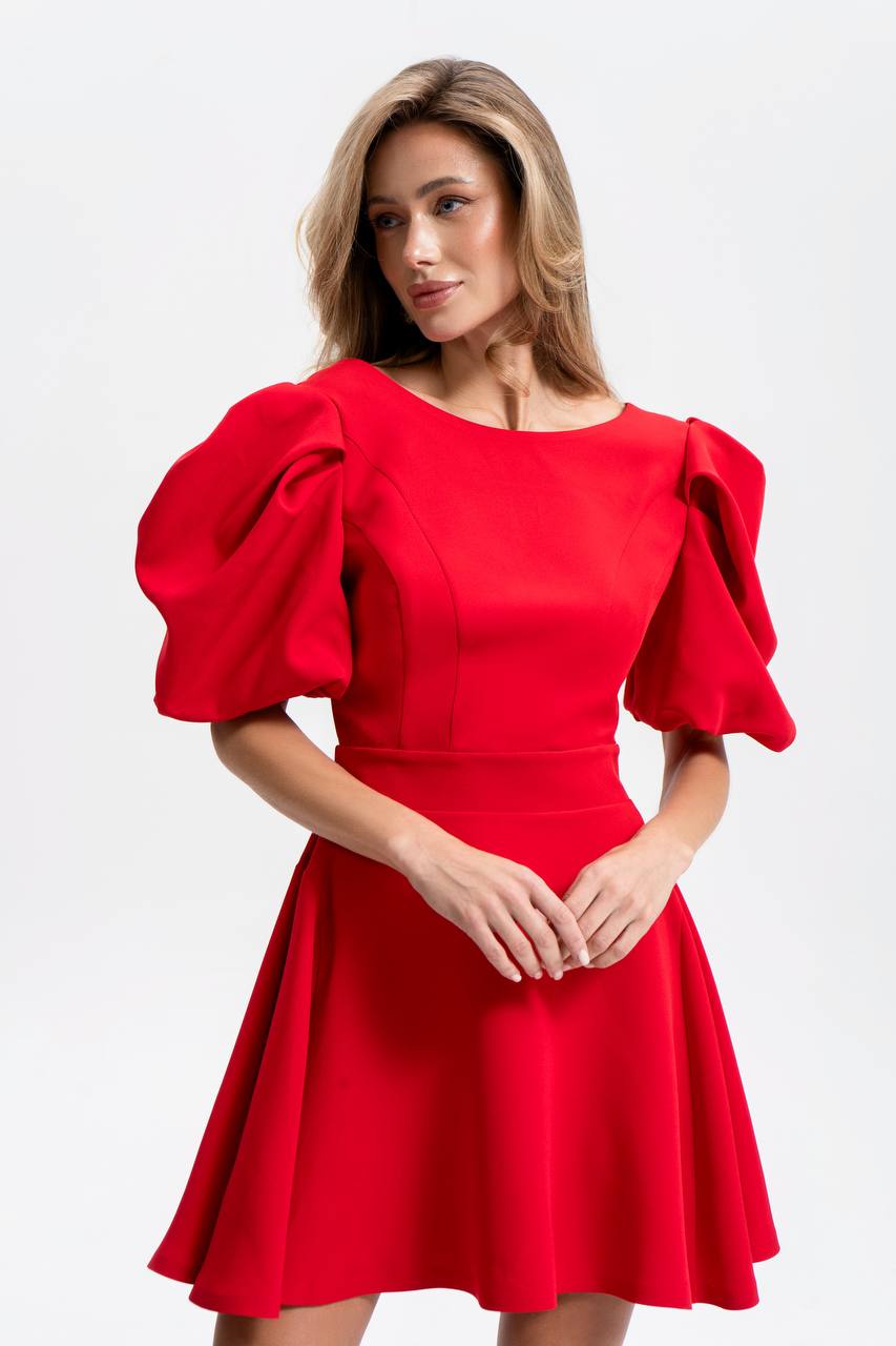 Woman wearing a red dress with puff sleeves on a white background