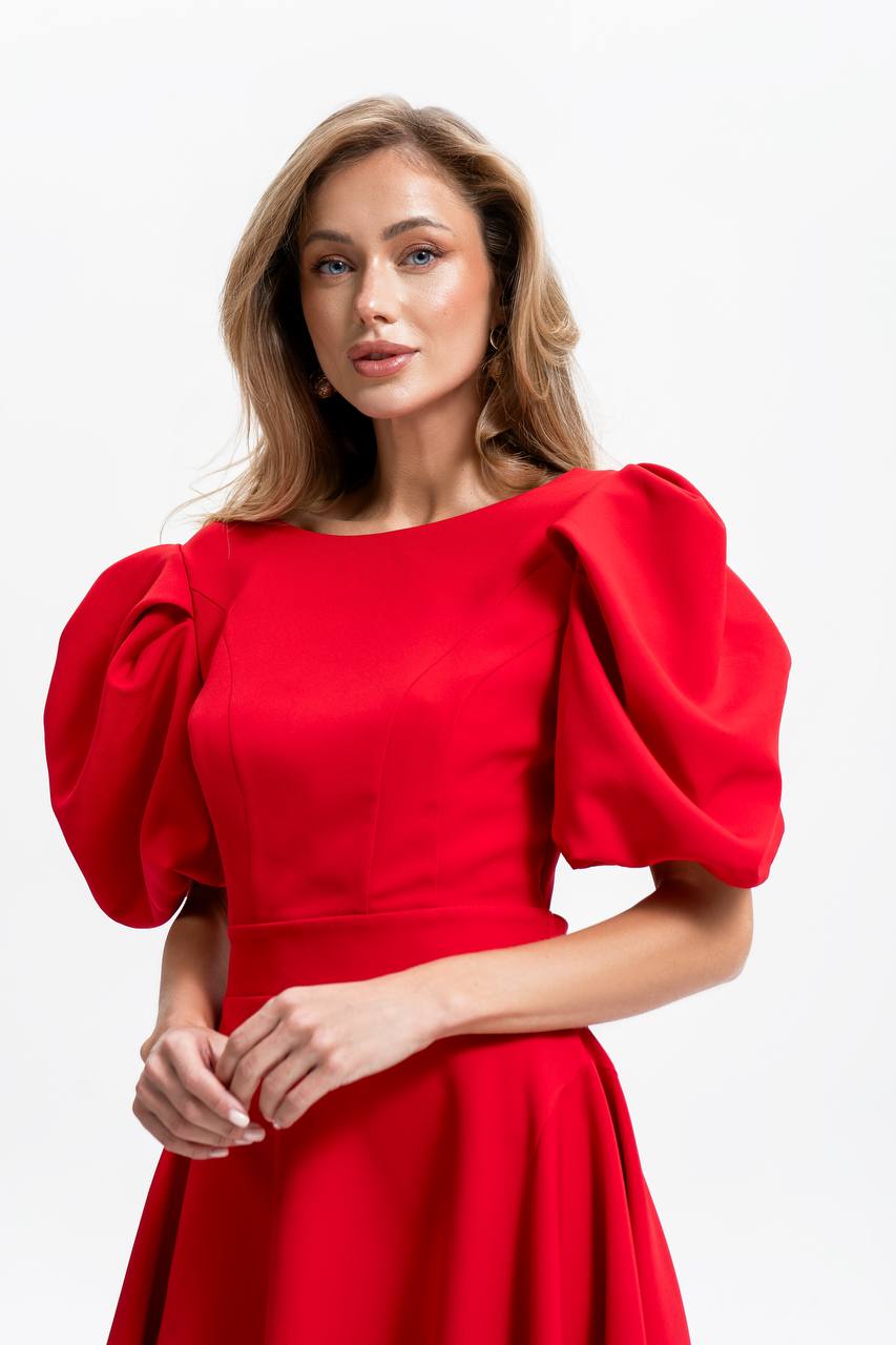 Woman wearing a red dress with puffed sleeves on a white background