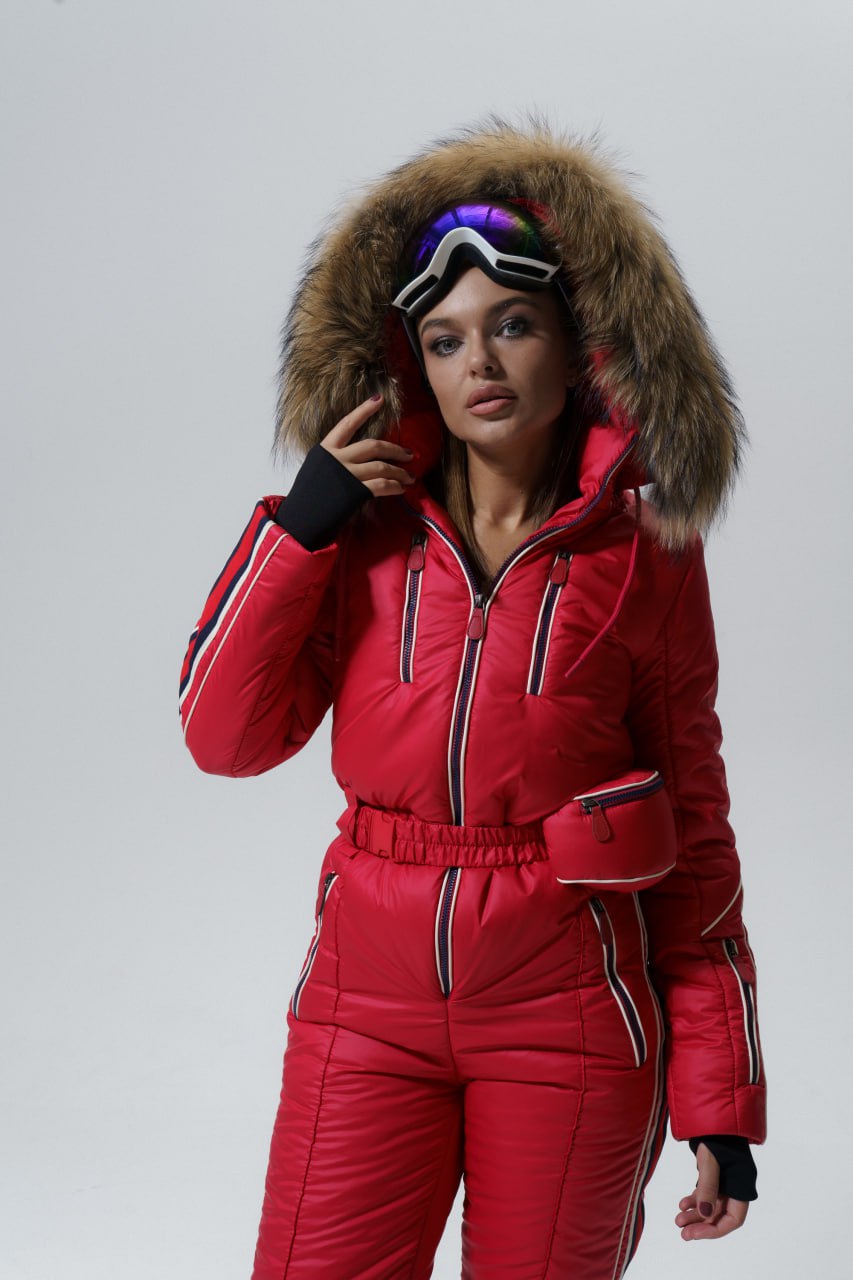 Person wearing a red ski suit with a fur-lined hood on a plain background
