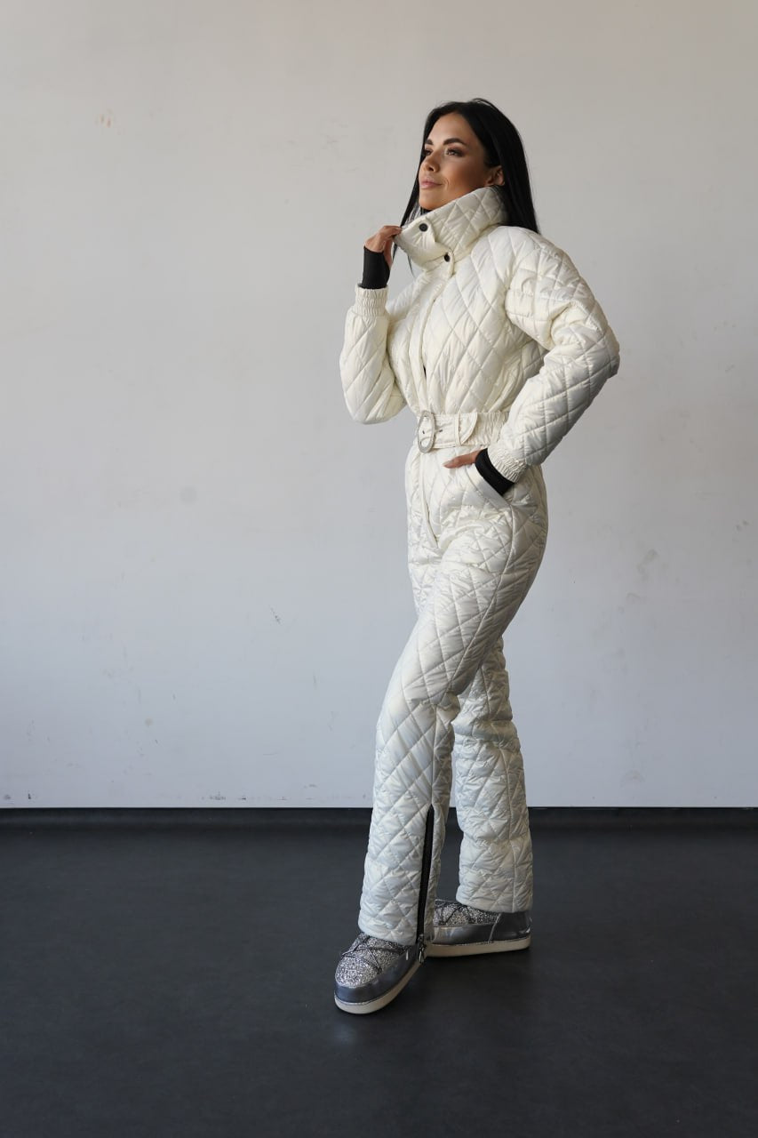 Person wearing a white quilted snowsuit against a plain background