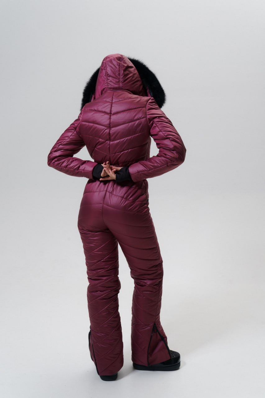 Person wearing a maroon puffer suit on a white background