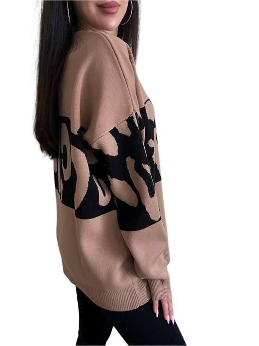 Beige sweater with black abstract patterns worn by a person on a white background