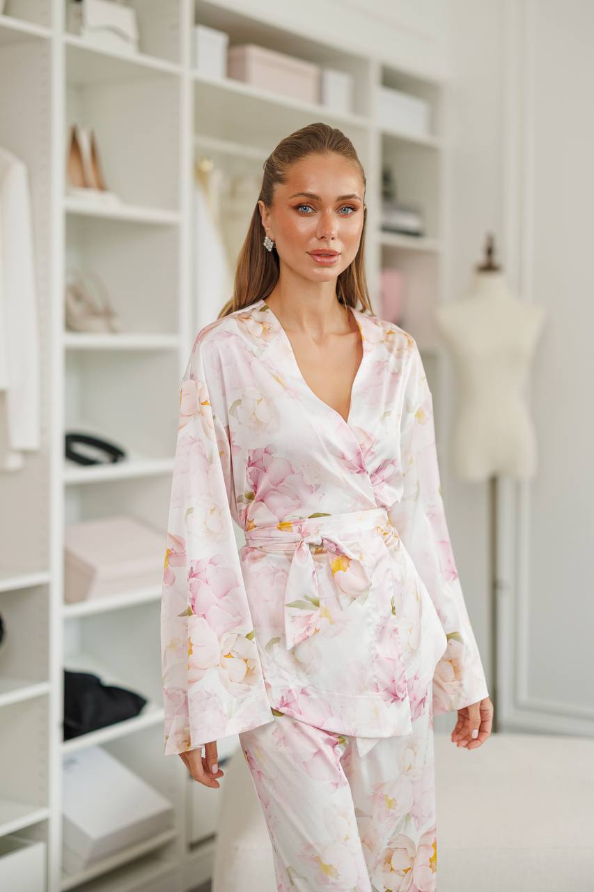 Woman wearing a floral robe in a room with shelves and a mannequin.