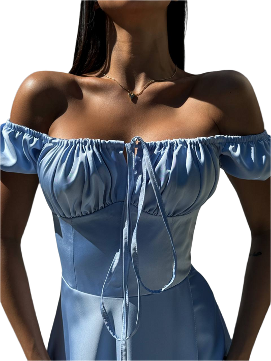 Blue off-shoulder top worn by a person on a white background