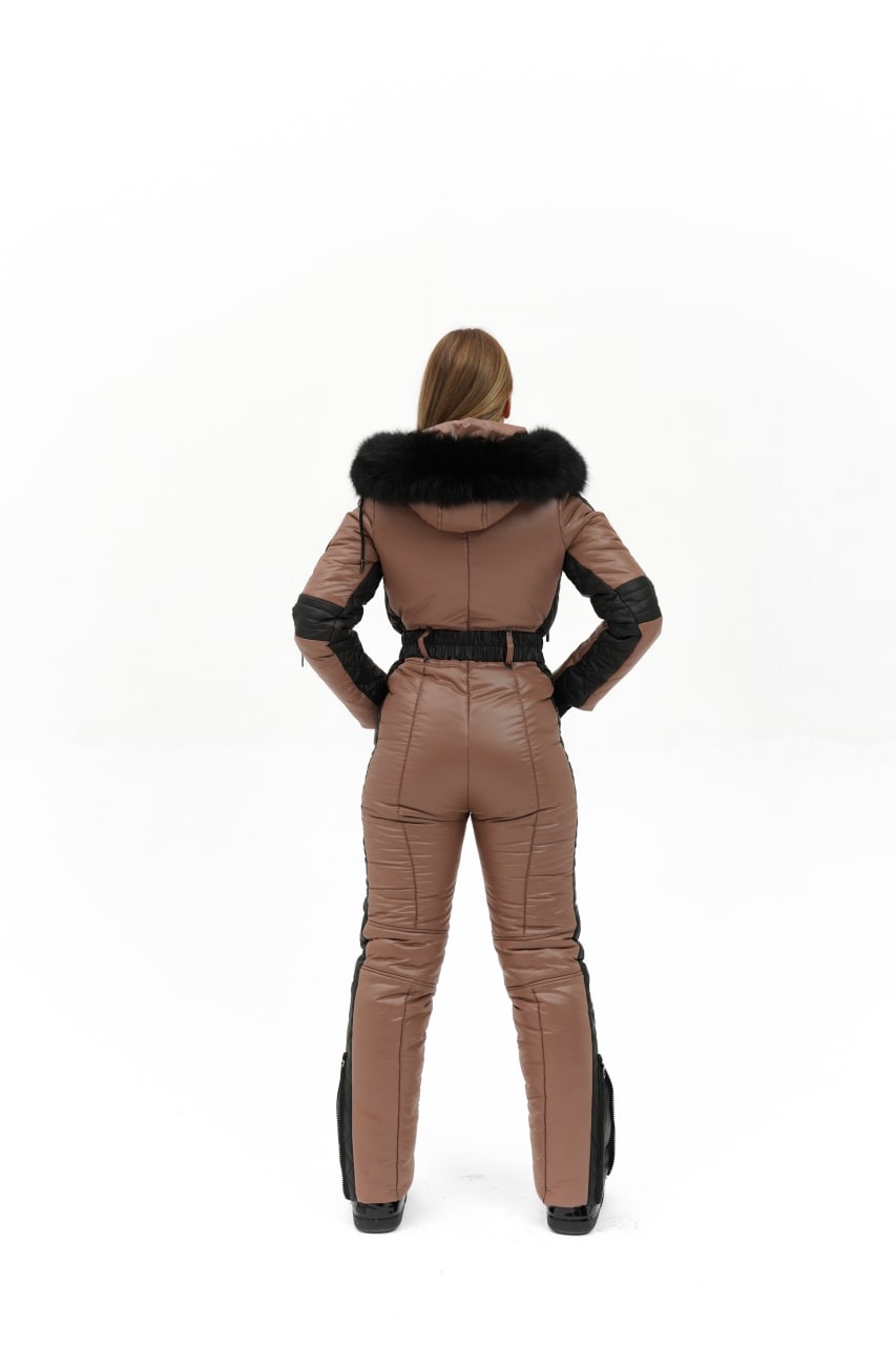 Person wearing a brown leather jumpsuit with black fur trim on a white background