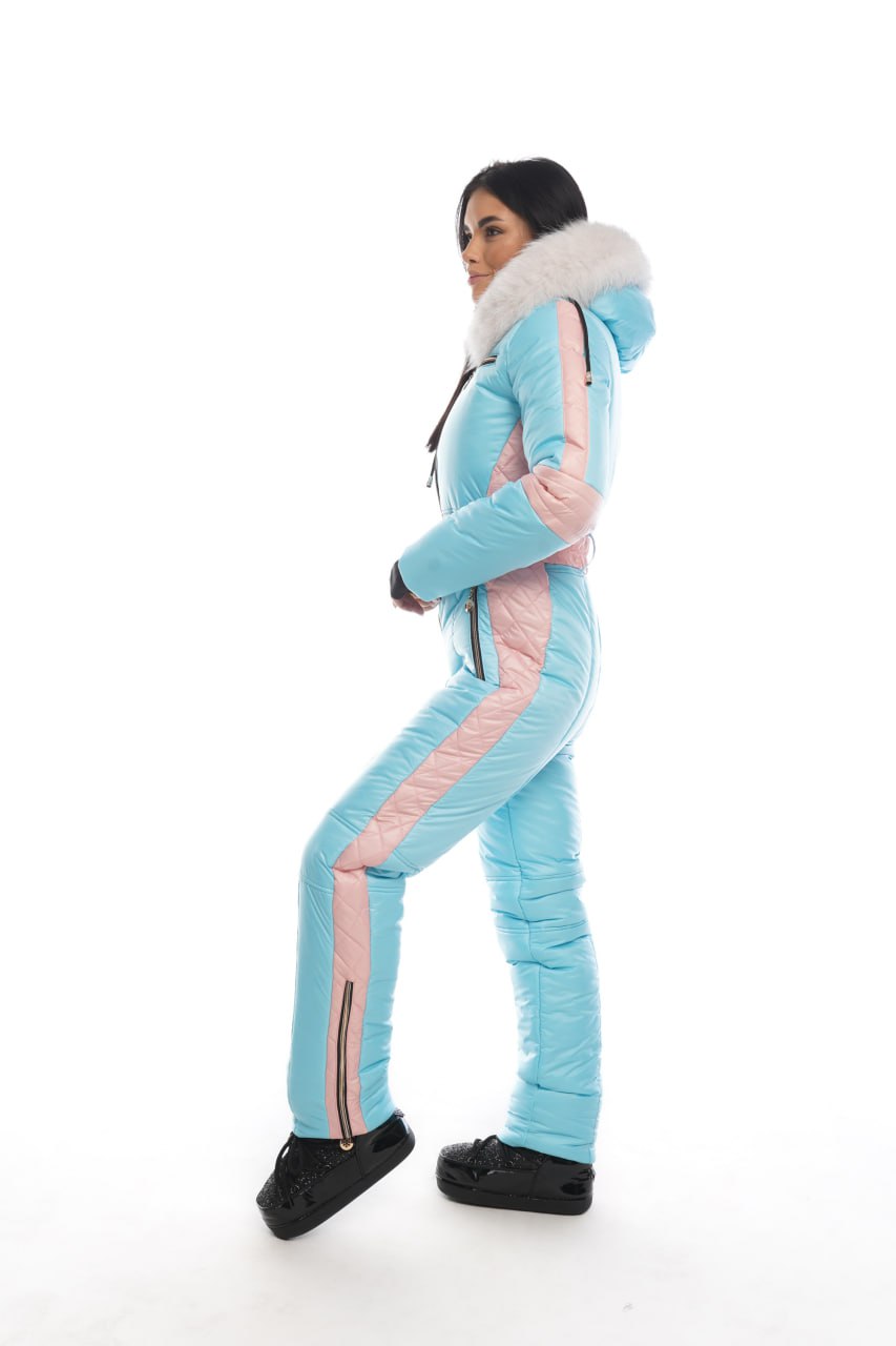 Person wearing a light blue and pink snowsuit with a hood on a white background