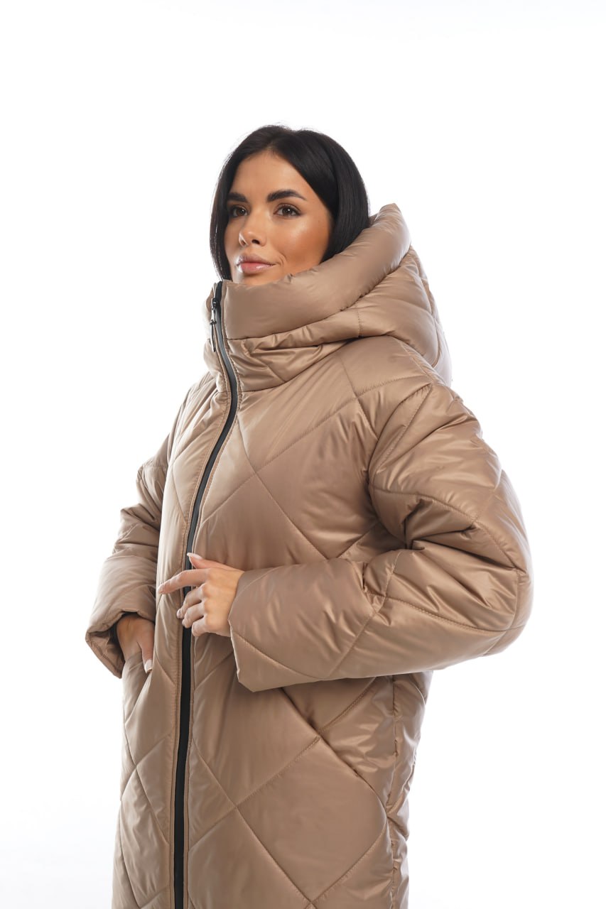 Woman wearing a beige quilted jacket on a white background