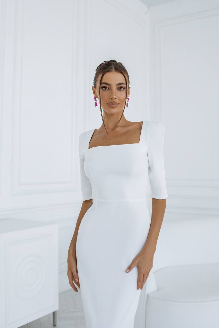 Woman wearing a white dress with a plain background