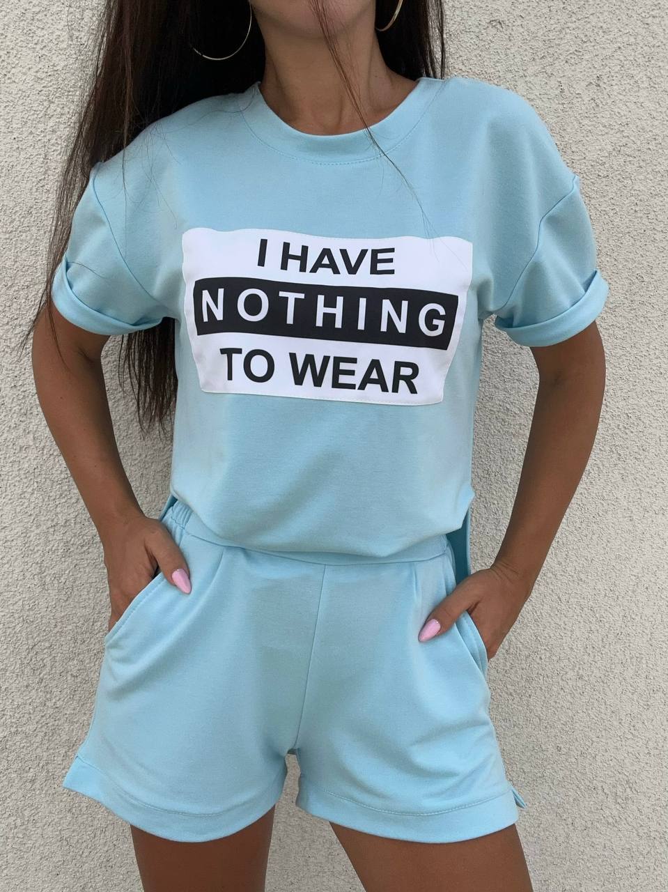 Person wearing a light blue outfit with a shirt and shorts, featuring text on the shirt.
