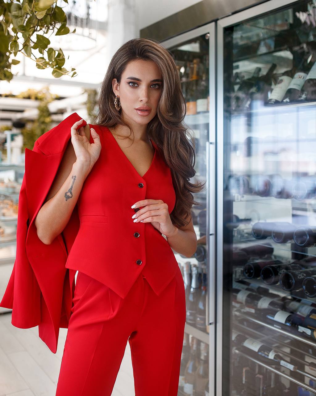 Woman in a red outfit standing in a wine cellar