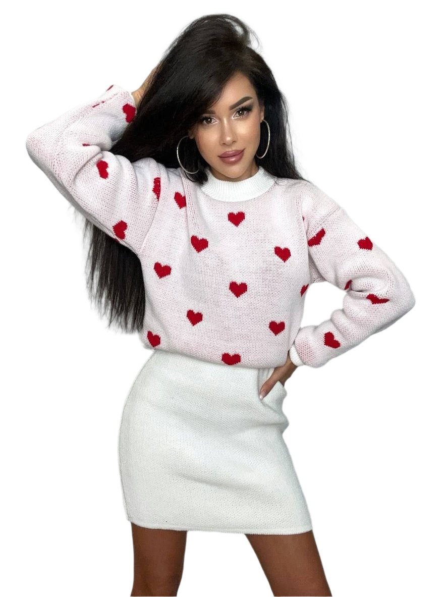 Woman wearing a white sweater with red heart patterns and a white skirt on a white background