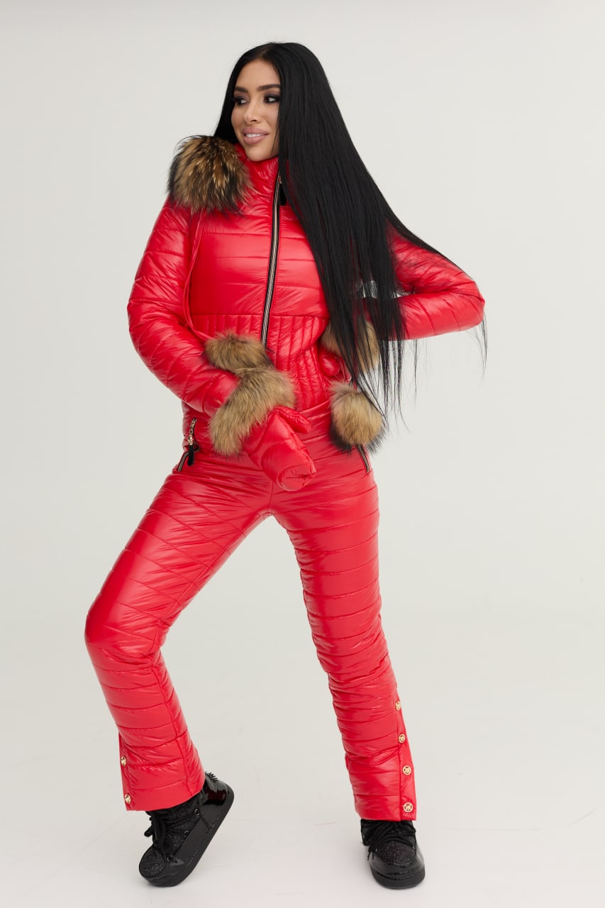 Person wearing a red puffer suit with fur accents on a white background