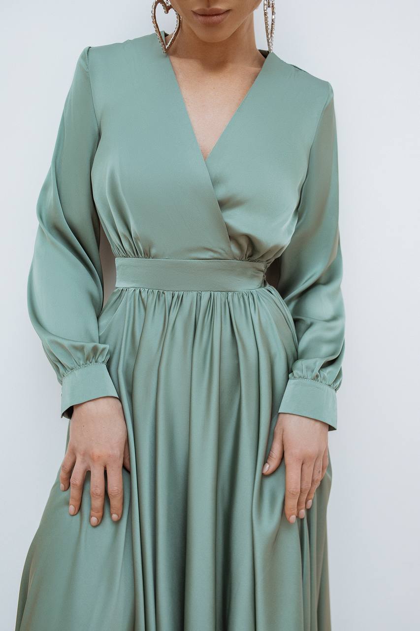 Mint green dress with long sleeves on a white background