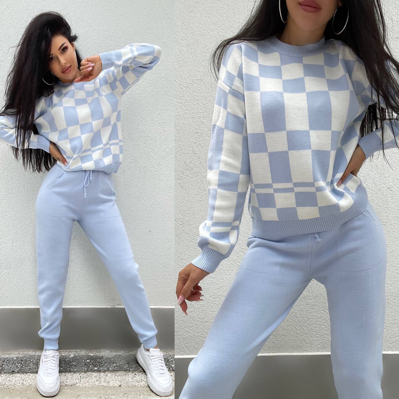Woman wearing a blue and white checkered sweater and pants against a gray wall.