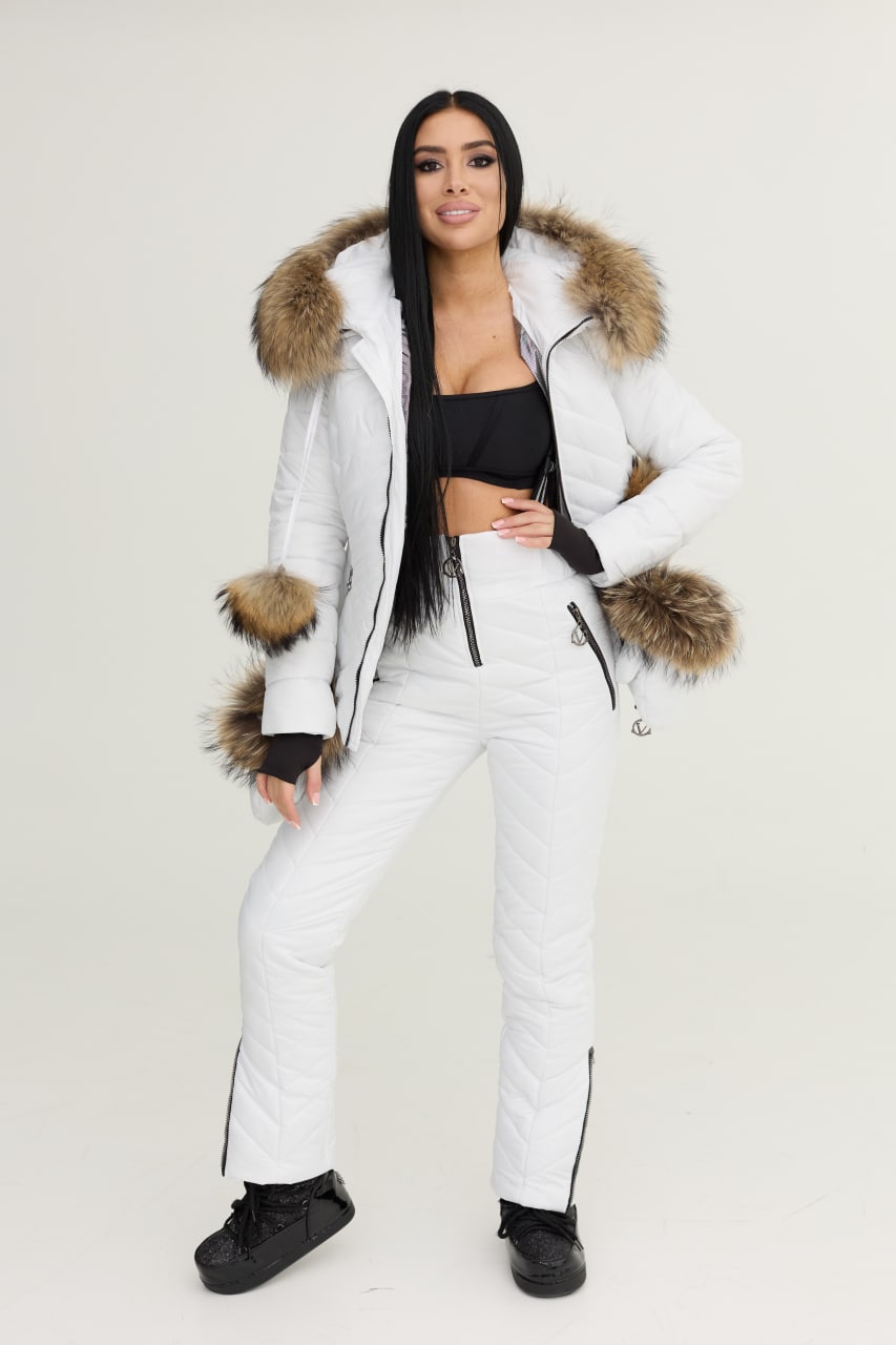 Woman wearing a white winter coat with fur trim on a plain background