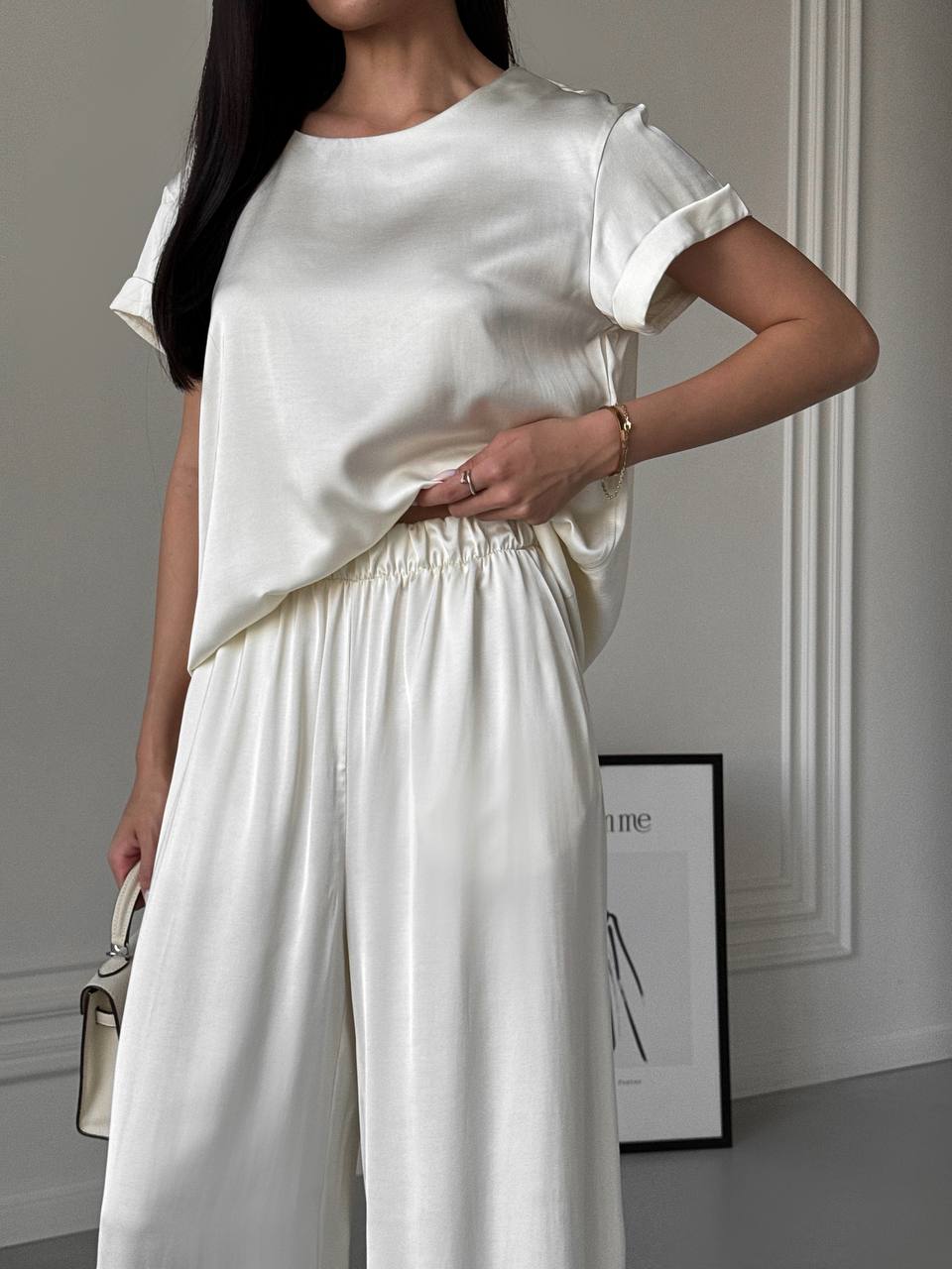 Person wearing a white outfit in a minimalistic setting