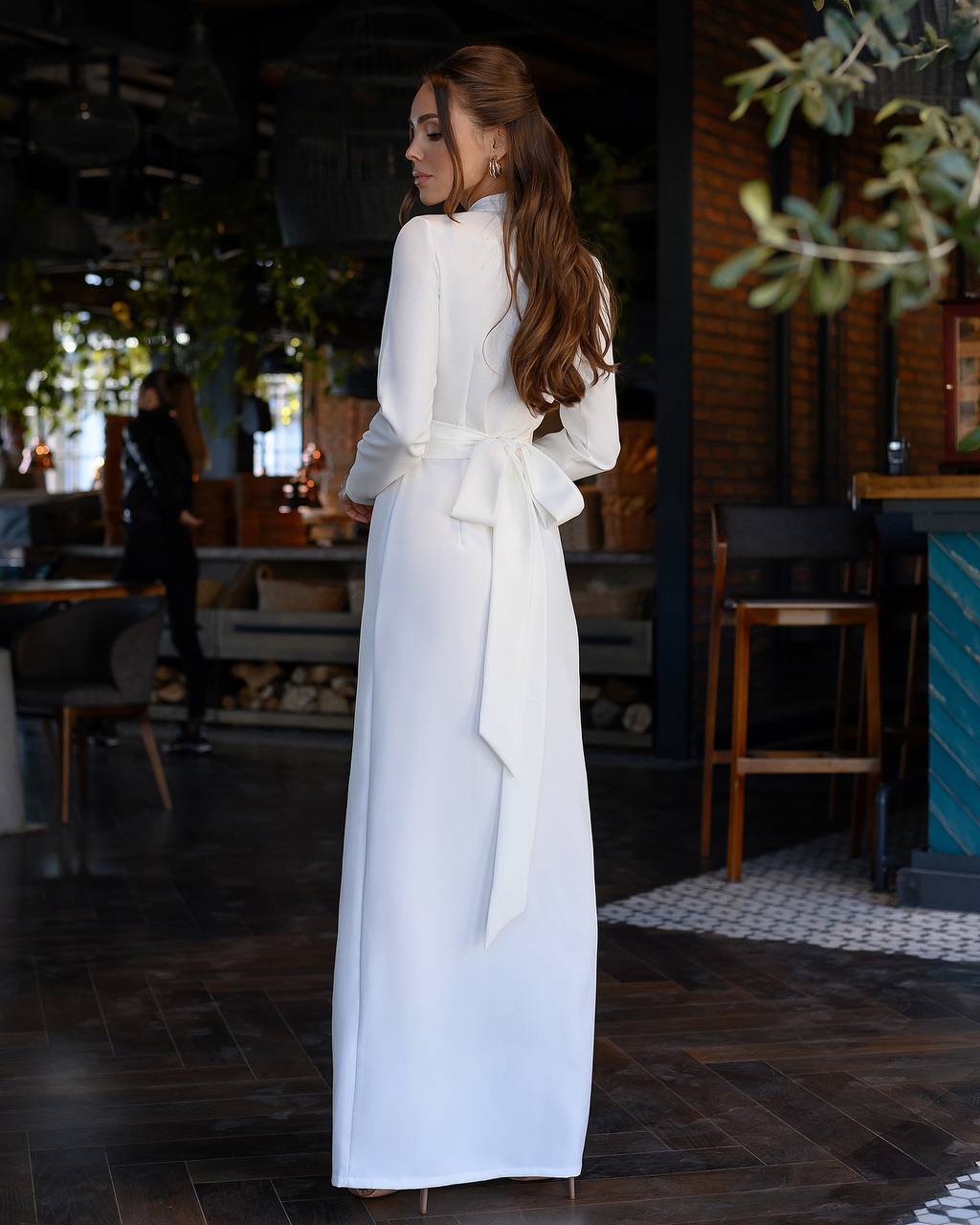 Woman in a white dress standing in a restaurant setting