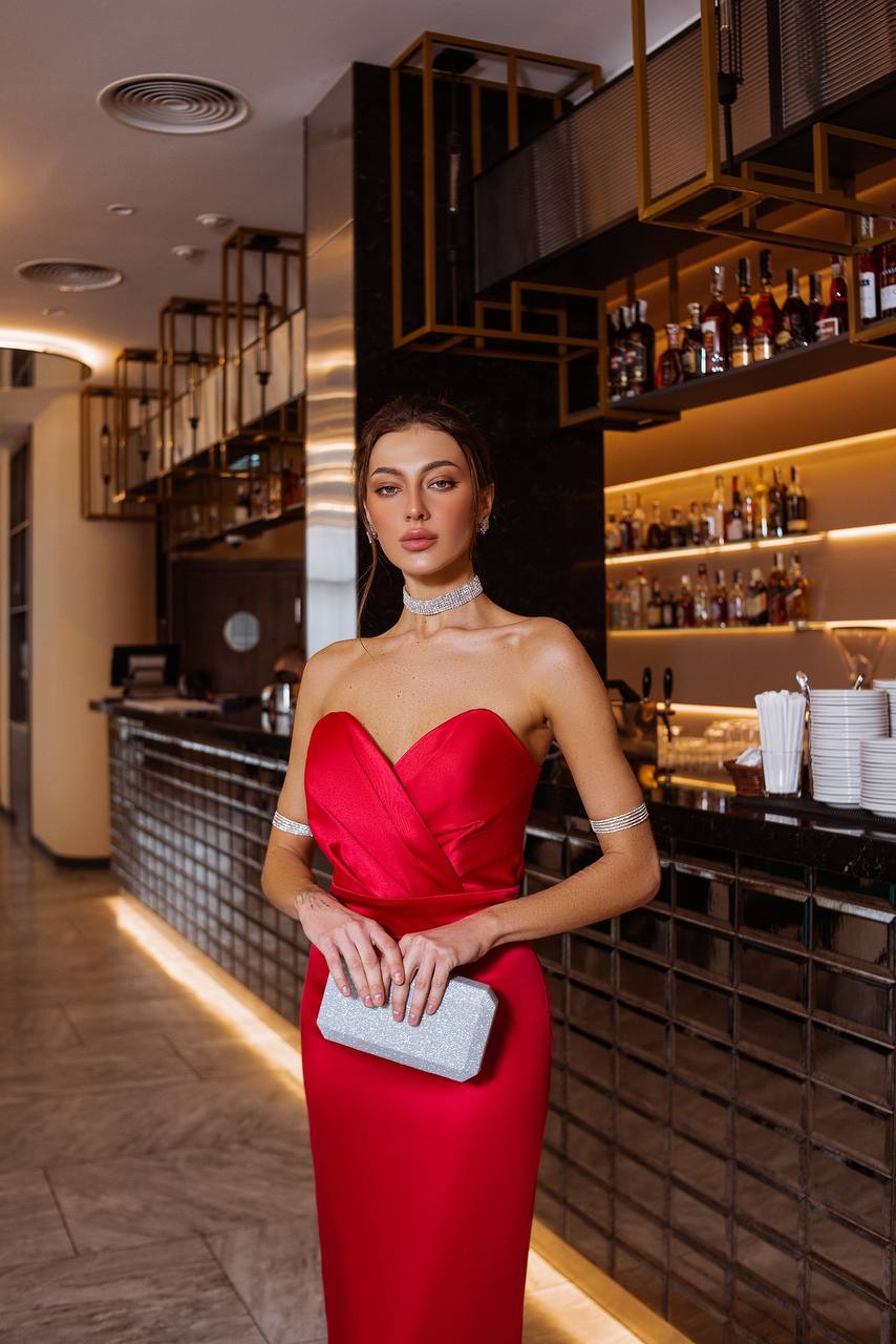 Woman in a red dress standing in a bar setting