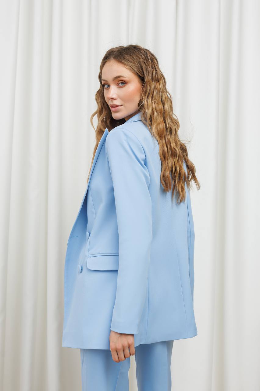 Woman wearing a light blue suit against a white background