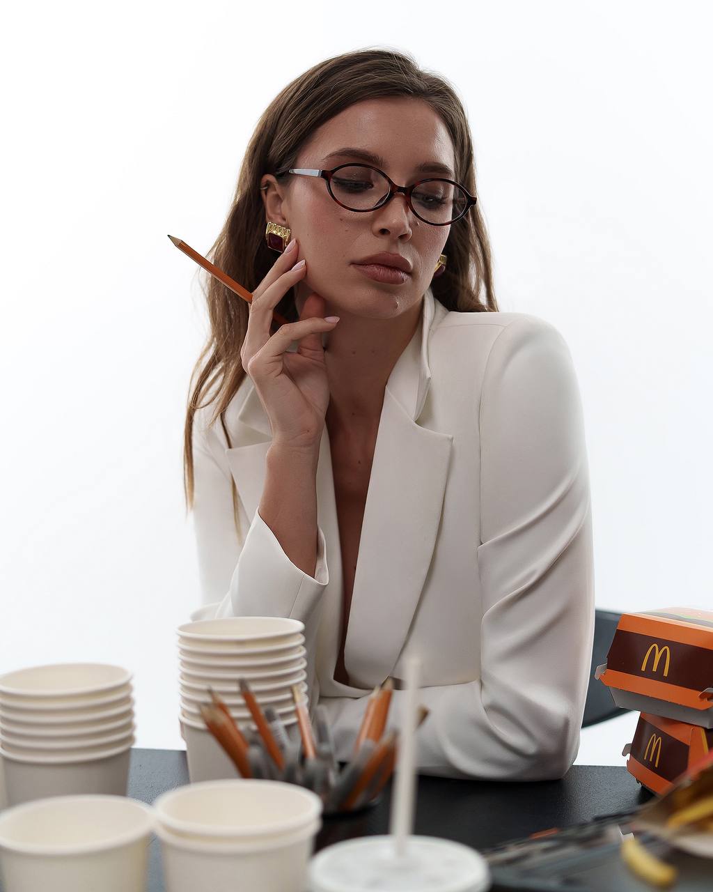 Woman in a white blazer sitting at a table with McDonald's products
