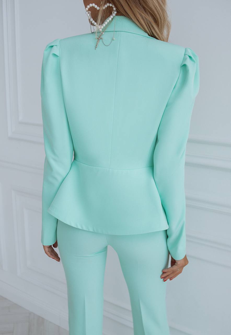 Mint green suit worn by a person against a white background