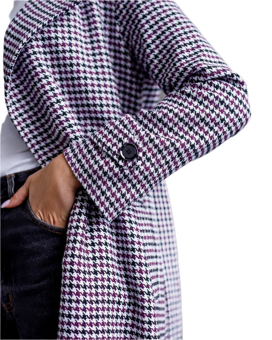 Houndstooth patterned coat with a button on a white background