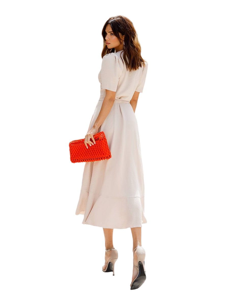 Woman in a white dress holding a red clutch on a white background