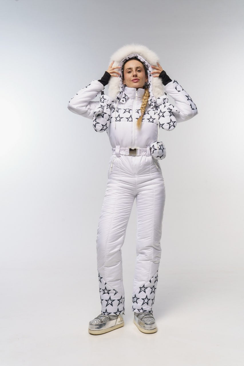 Person wearing a white snowsuit with star patterns on a light gray background