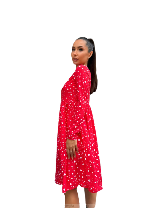 Woman wearing a red dress with white patterns on a white background